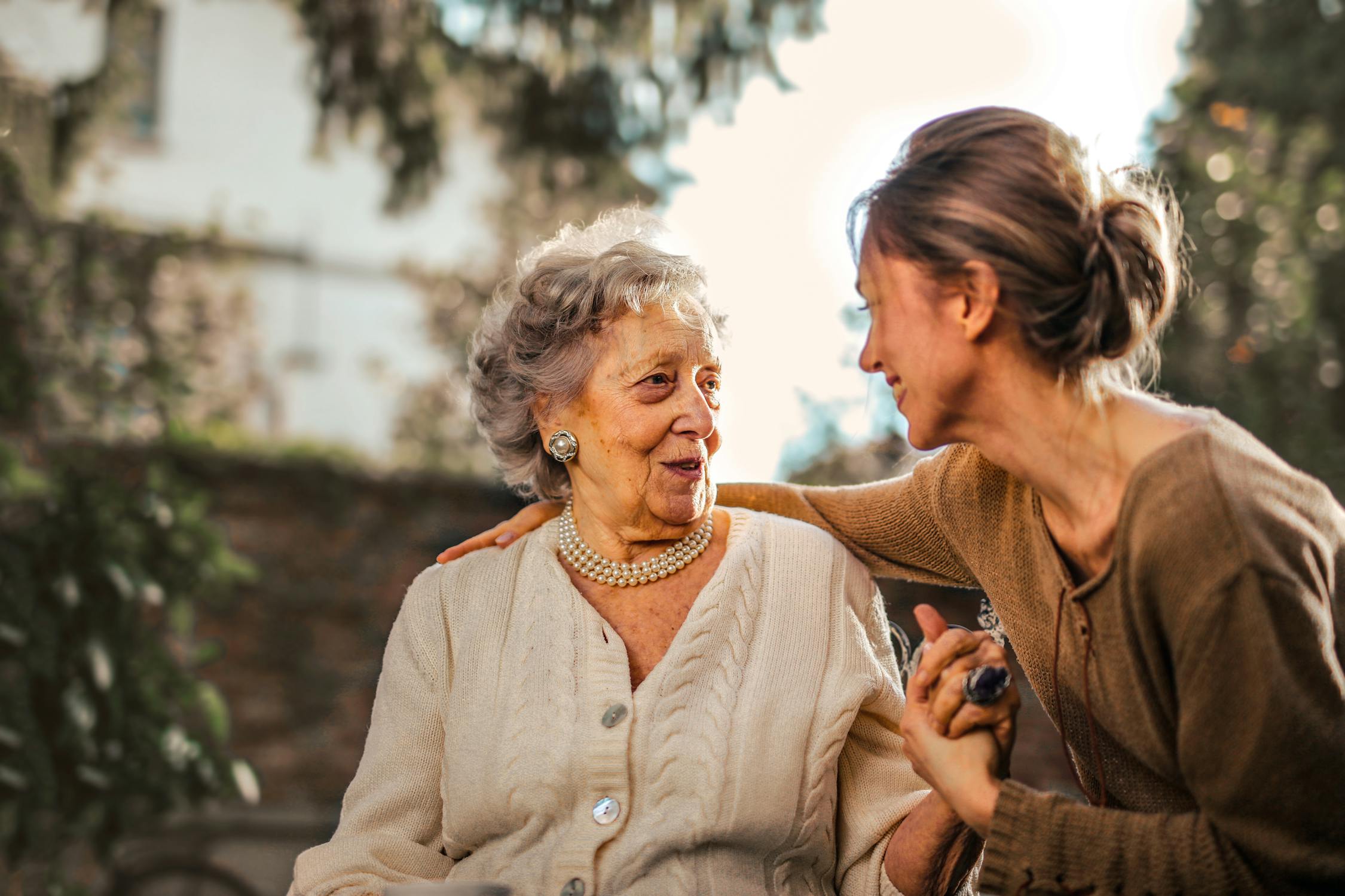 Caregiver supporting elderly client outdoors